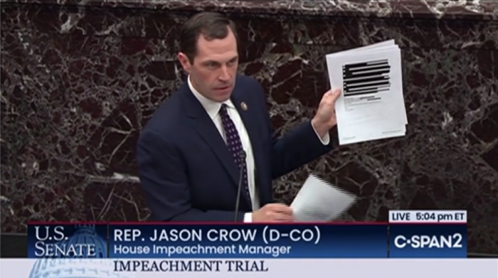 Representative Jason Crow holds up a heavily-redacted email from the Office of Management and Budget during the Senate impeachment trial on Wednesday